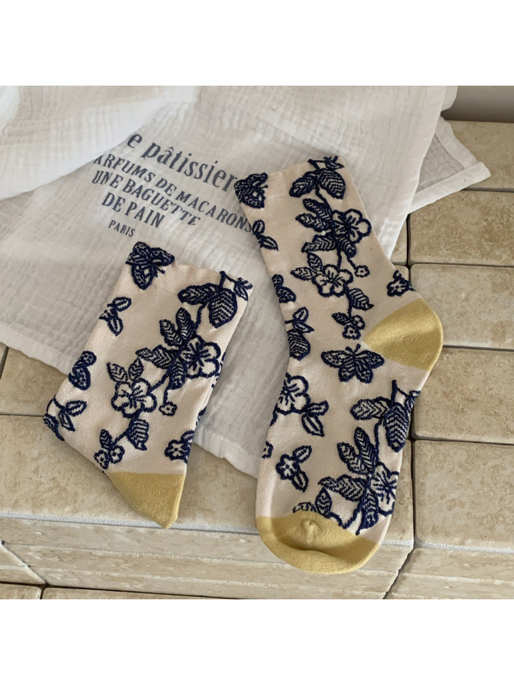 Cream floral and butterfly crew socks with navy motifs and mustard toe and heel panels