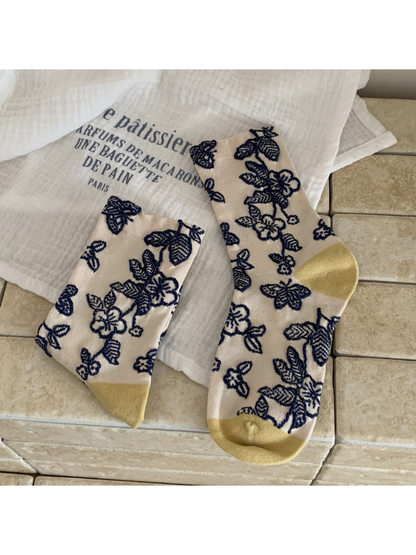Cream floral and butterfly crew socks with navy motifs and mustard toe and heel panels