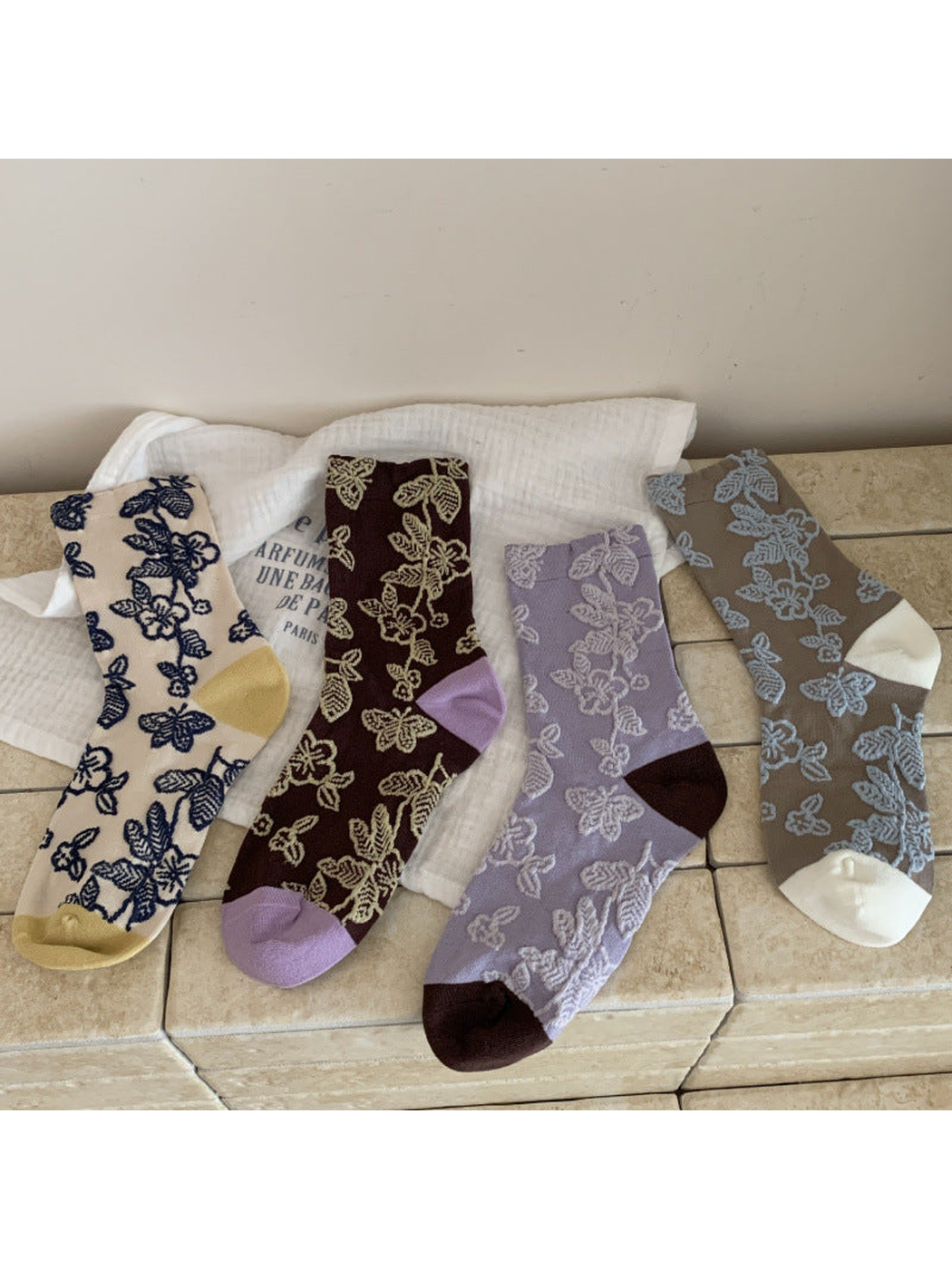 Four floral and butterfly crew sock colorways displayed together