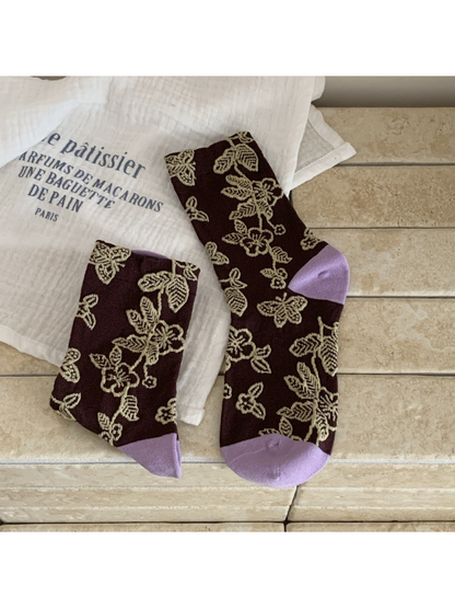Dark brown floral and butterfly crew socks with beige motifs and light purple toe and heel panels