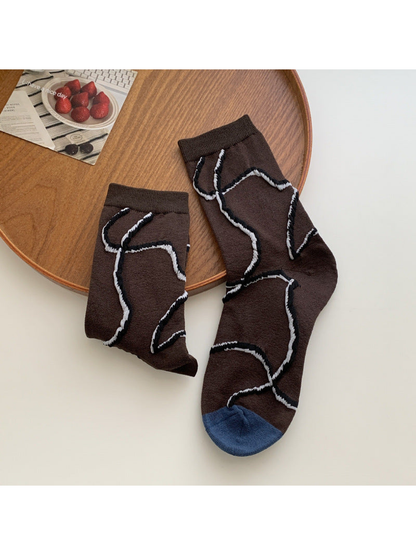 Dark brown crew socks with abstract white and black outlines