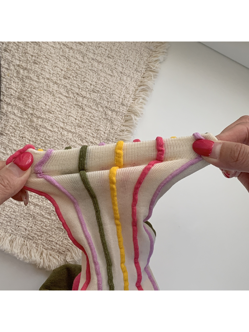 Close-up of an ivory striped sock stretched to show the knit structure