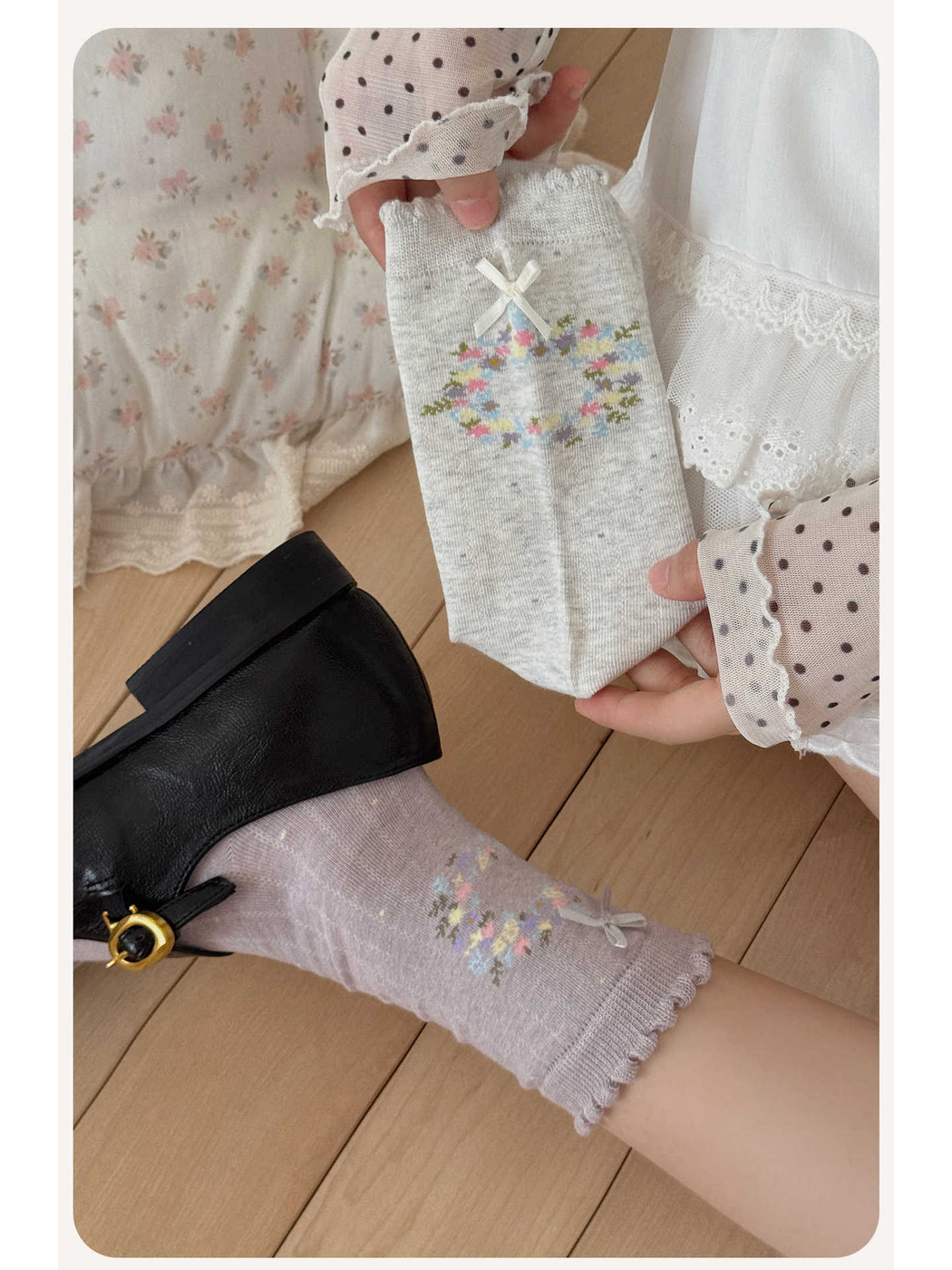 Close-up of gray and purple socks with floral wreath motifs and bows