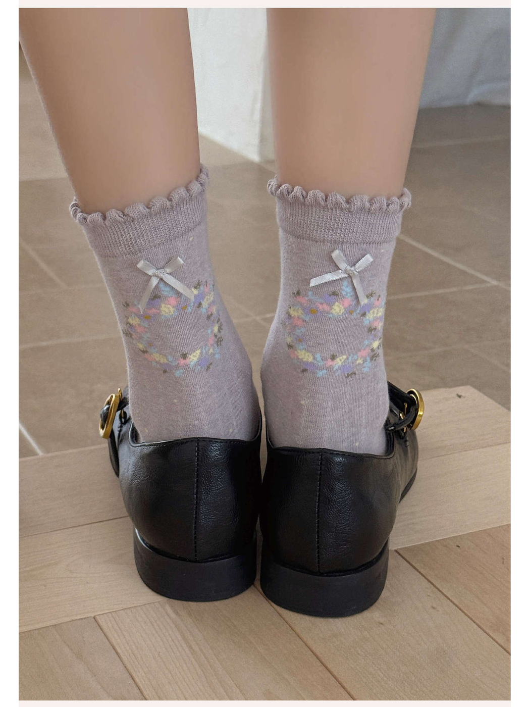 Heather purple floral wreath socks shown from the back with black shoes