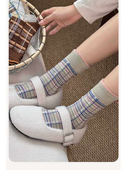 Gray plaid crew socks styled with white fuzzy shoes