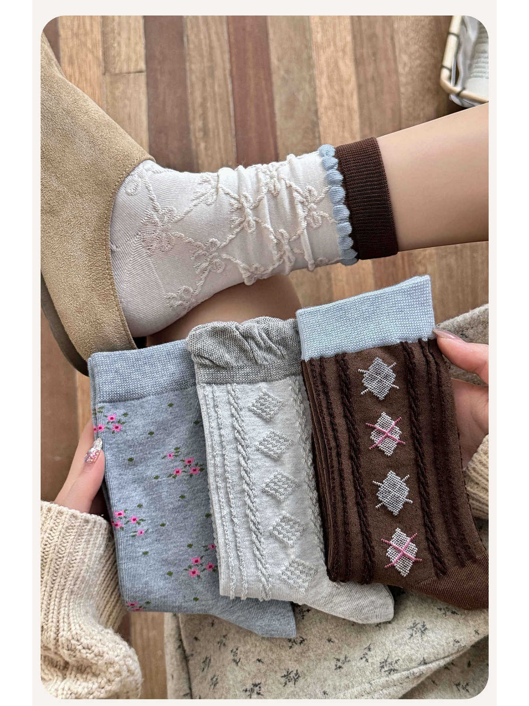 Ivory patterned crew socks worn with three additional sock styles held in hand