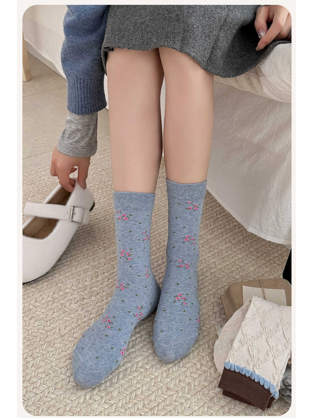 Blue-gray floral crew socks worn in a seated indoor setting