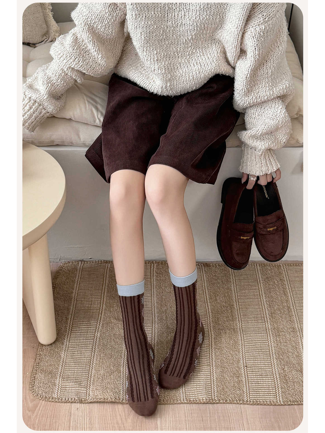 Coffee brown argyle crew socks worn with a neutral sweater and shorts
