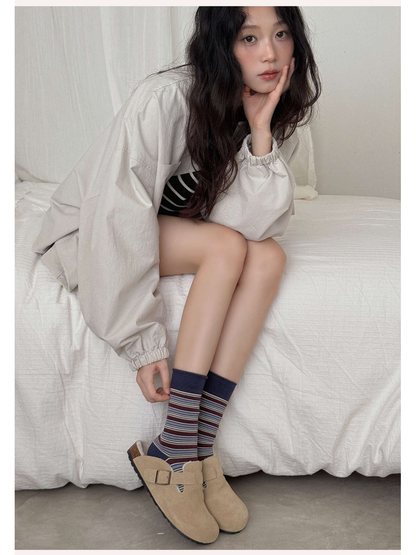 Burgundy and navy striped crew socks styled with beige shoes