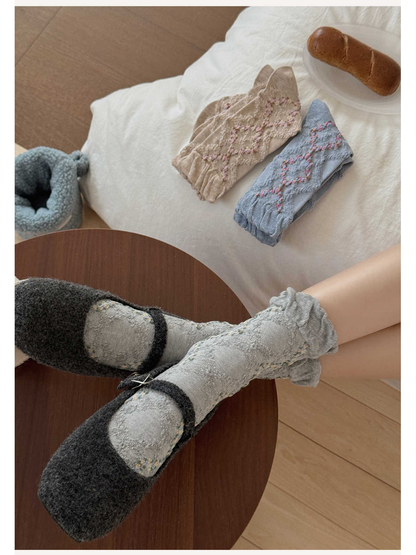 Gray floral argyle crew socks worn with dark flats beside folded color options