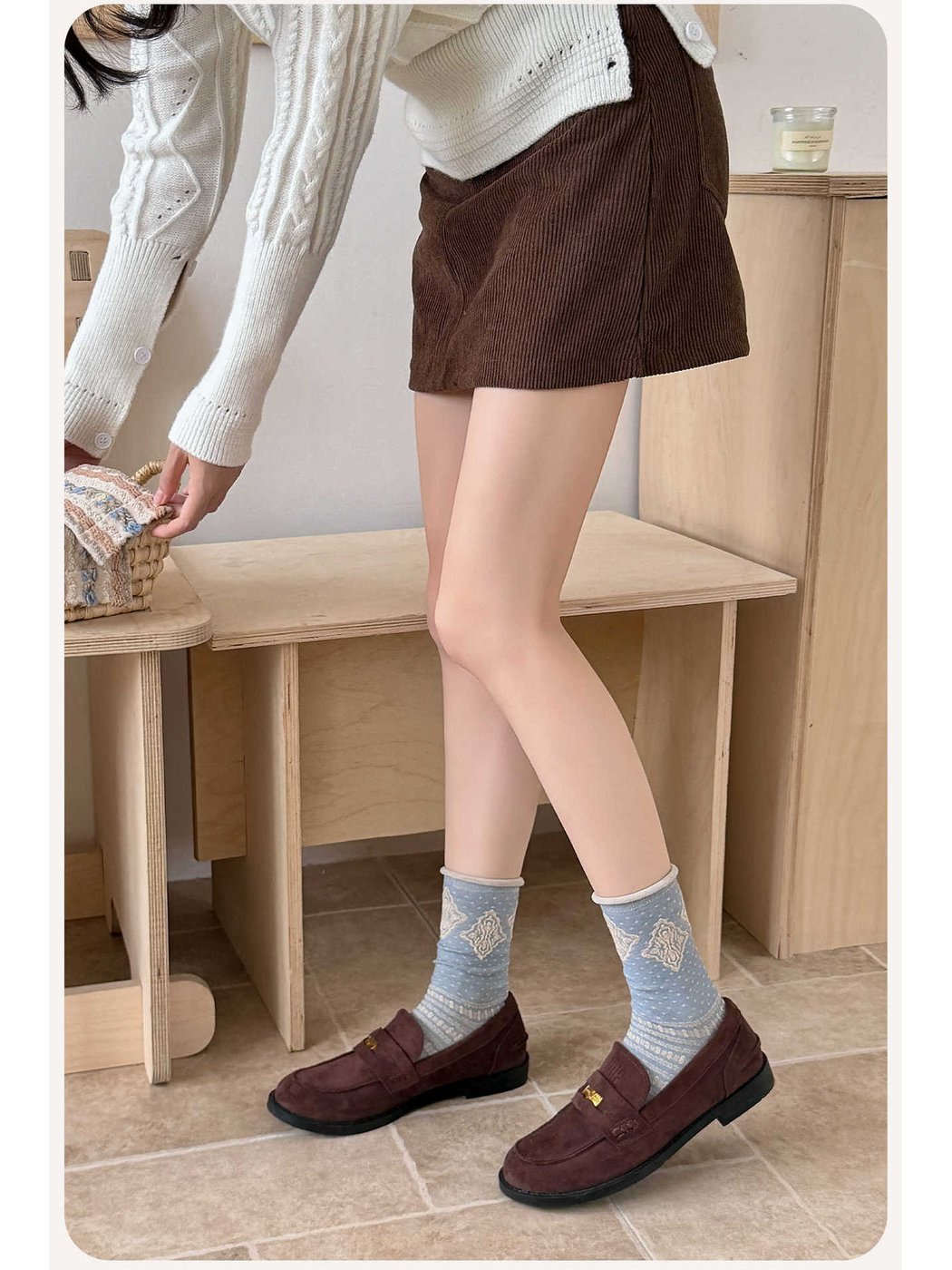 Dusty blue diamond-pattern crew socks styled with brown loafers
