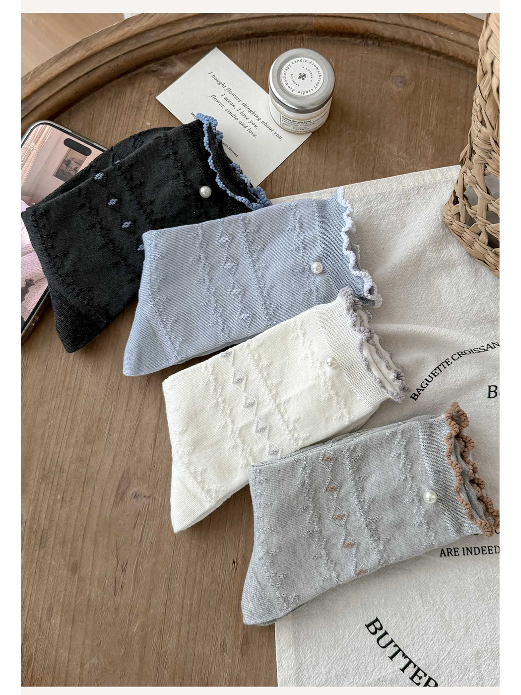 Four color variants of ruffled pointelle socks arranged in a flat lay