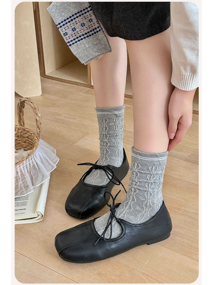 Gray cable-textured crew socks styled with black lace-up flats