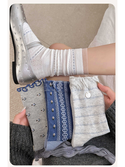 White socks worn with a silver flat beside three folded sock styles