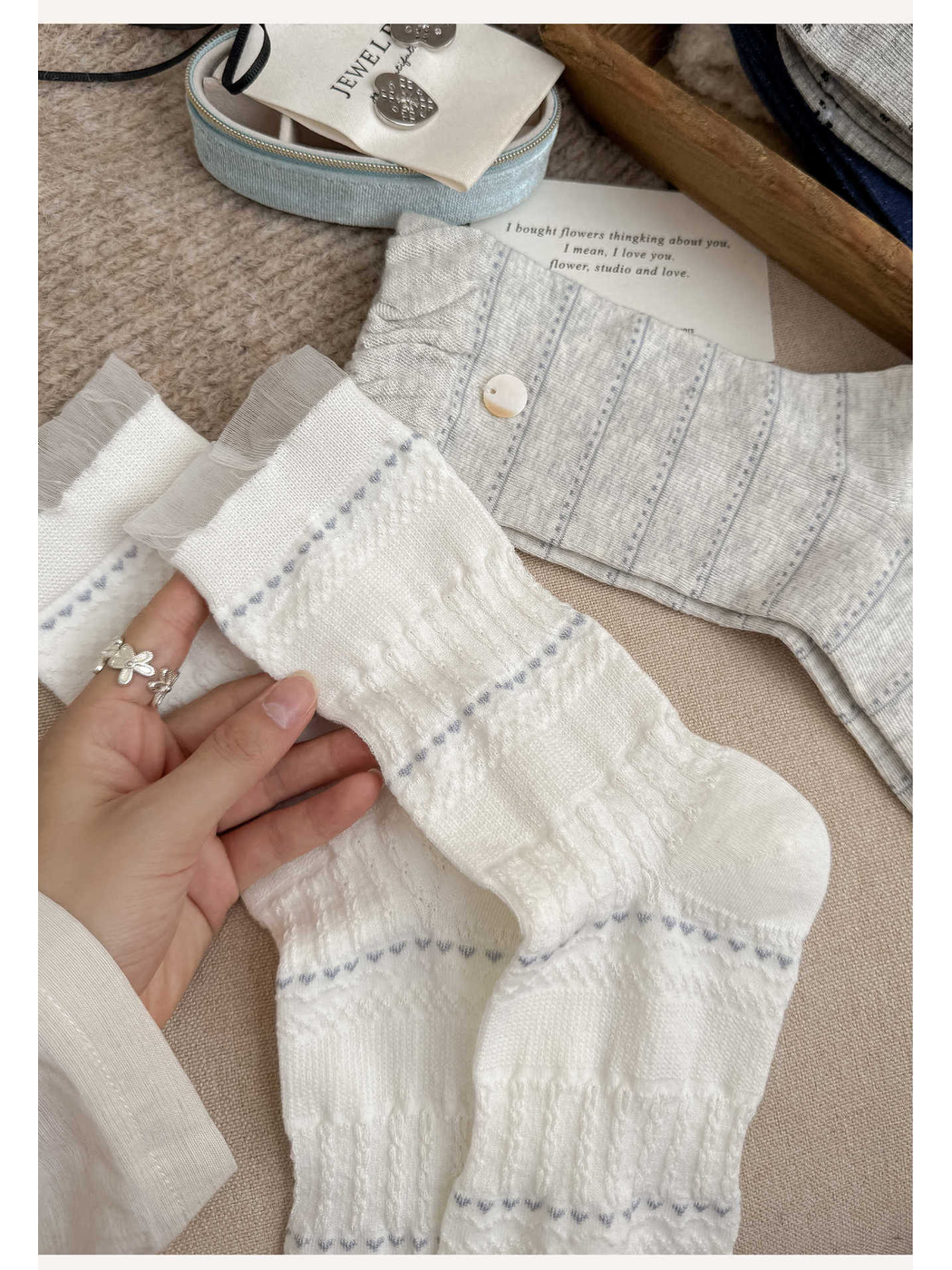 Close-up of white textured socks with pale blue accent rows and sheer cuffs