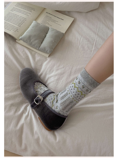 Light gray geometric crew sock worn with a gray buckle flat