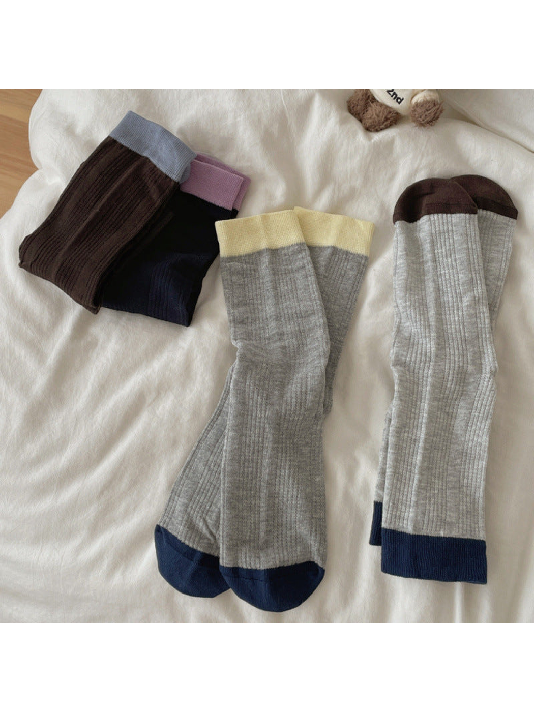 Five color-blocked ribbed crew sock styles arranged to show contrasting heels