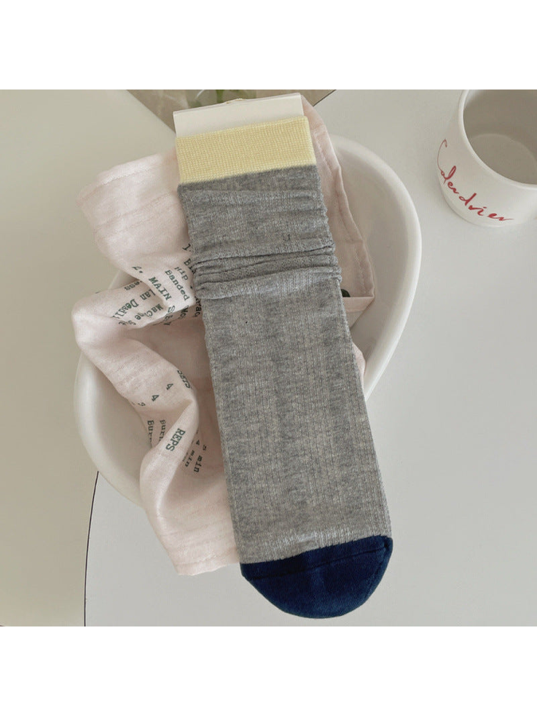 Heather gray ribbed crew sock with pale yellow cuff and navy toe
