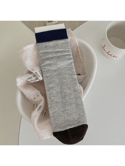 Light gray ribbed crew sock with navy cuff and dark brown toe