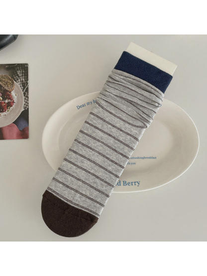Light gray striped crew sock with navy cuff and dark brown toe