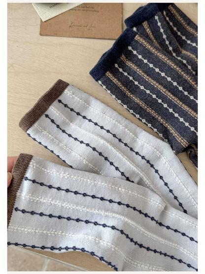 Close-up of the white and navy sock fabric with brown and navy cuffs