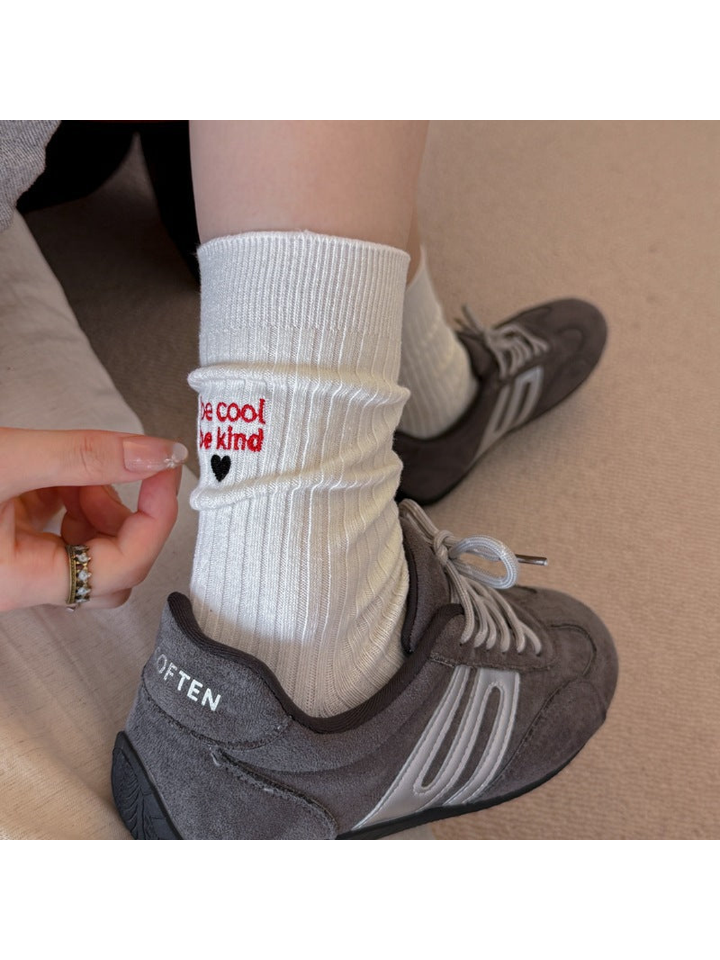 White ribbed crew socks worn with gray sneakers