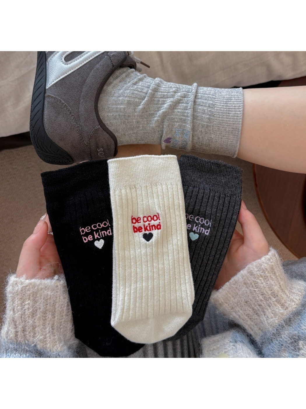 Black, white and dark gray embroidered crew socks displayed together