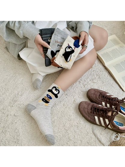 Penguin crew sock designs styled together in a seated scene