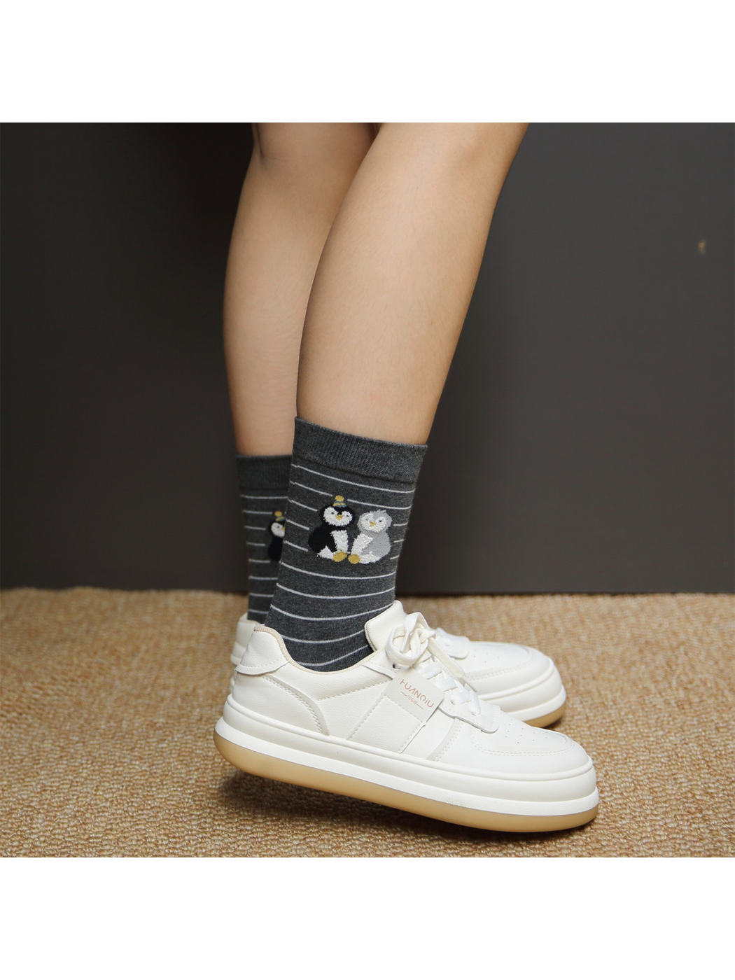Dark gray striped penguin crew socks worn with white sneakers