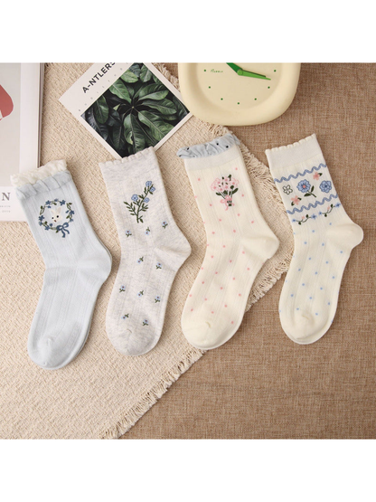 Four floral crew sock styles arranged in a flat lay