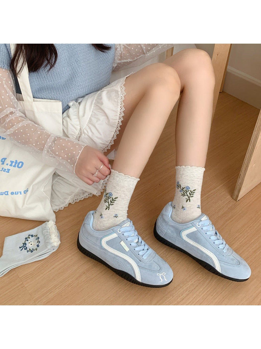 Heather gray floral crew socks worn with light blue sneakers