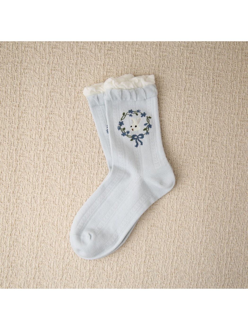 Light blue crew sock with rabbit wreath motif and layered ruffled cuff