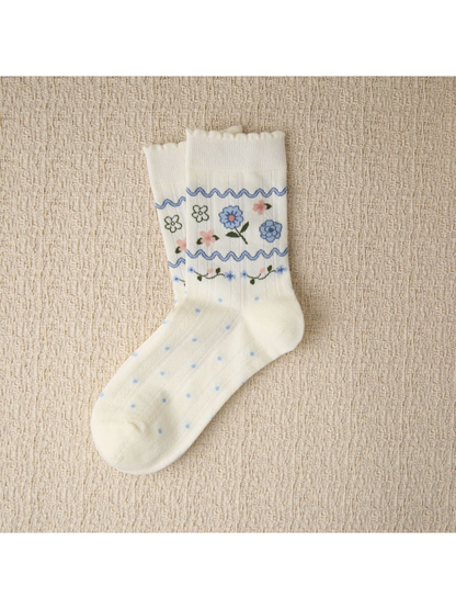 Ivory crew sock with blue floral bands, blue dots and scalloped cuff