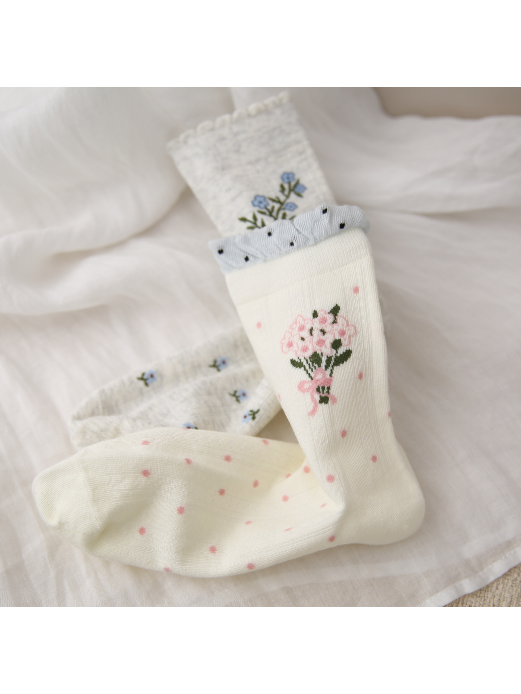 Close-up of pink bouquet, blue sprig and dotted sock patterns