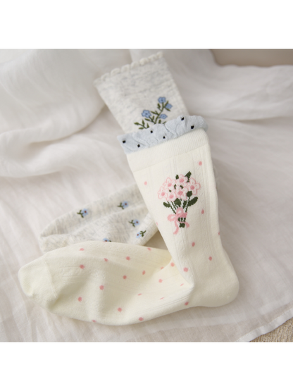 Close-up of pink bouquet, blue sprig and dotted sock patterns