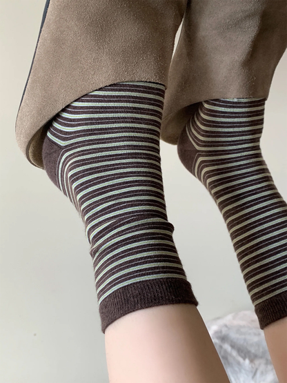 Dark brown striped crew socks worn beneath cropped trousers