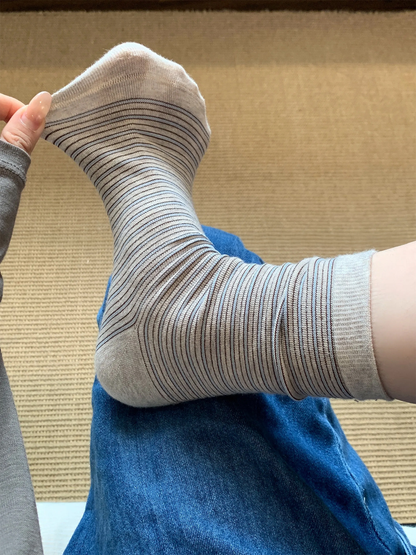 Beige striped crew sock stretched at the toe