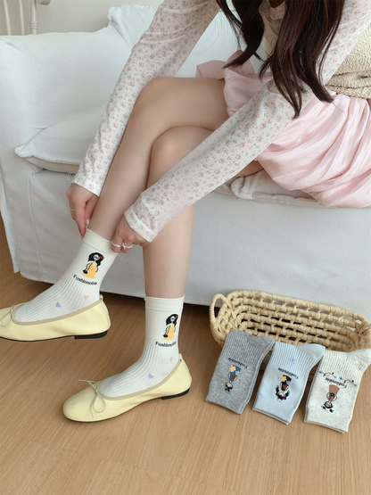 Ivory cartoon crew socks worn with pale yellow flats