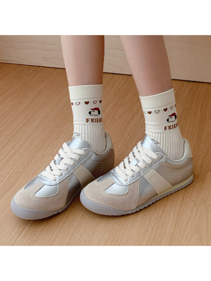 Ivory dog-motif crew socks worn with silver sneakers