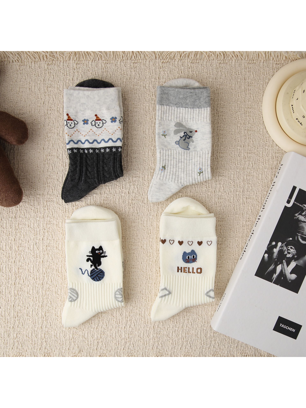 Four animal-motif crew sock designs arranged on a textured surface