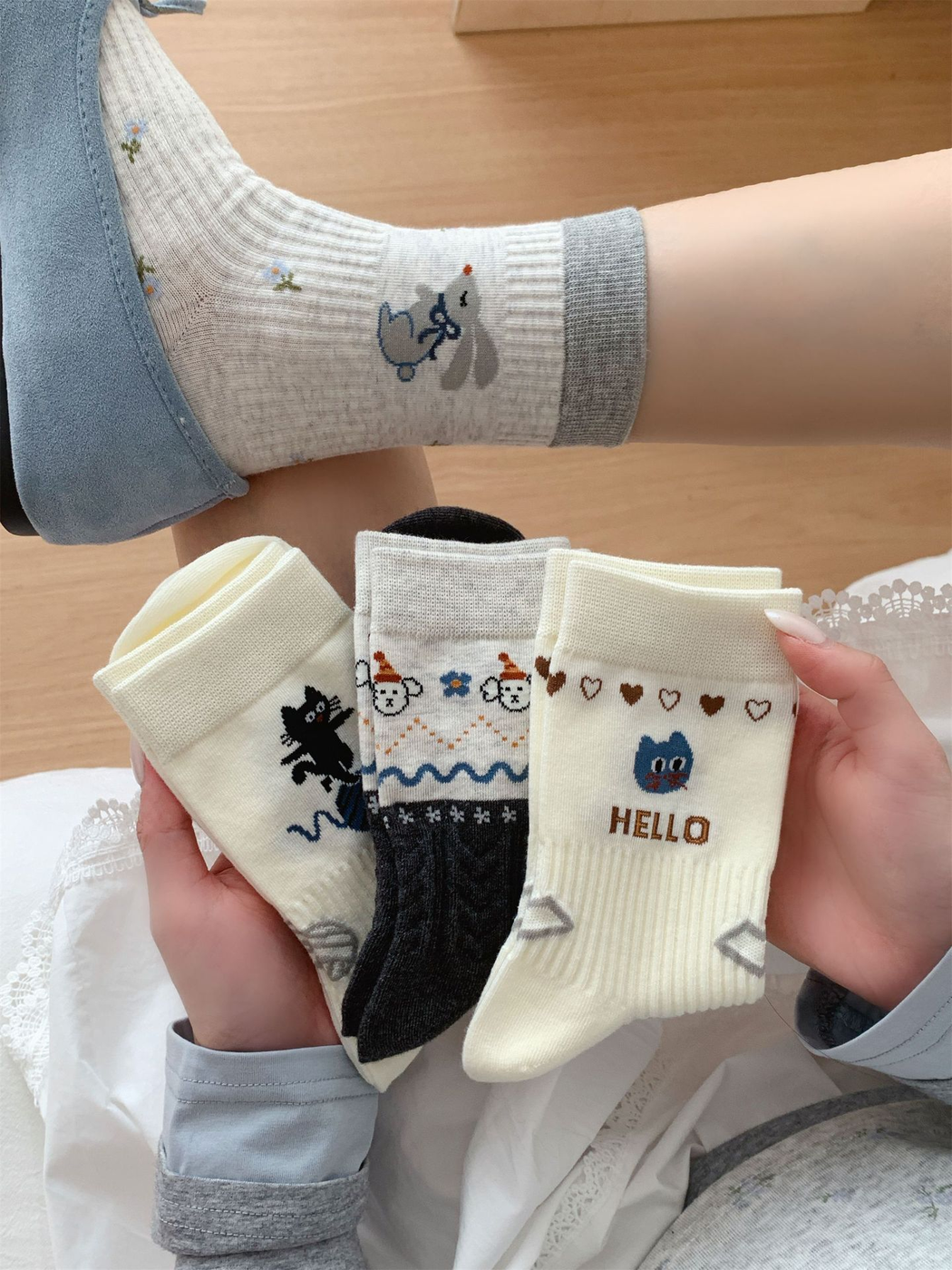 Light gray rabbit-motif crew sock worn while three coordinating designs are held