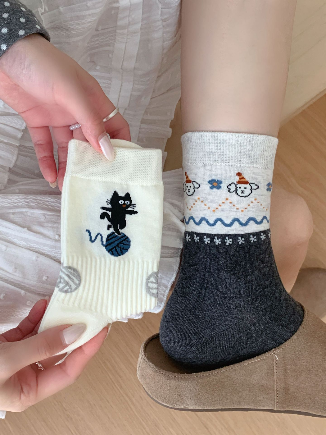Dark gray animal-pattern crew sock worn beside an ivory cat-and-yarn design