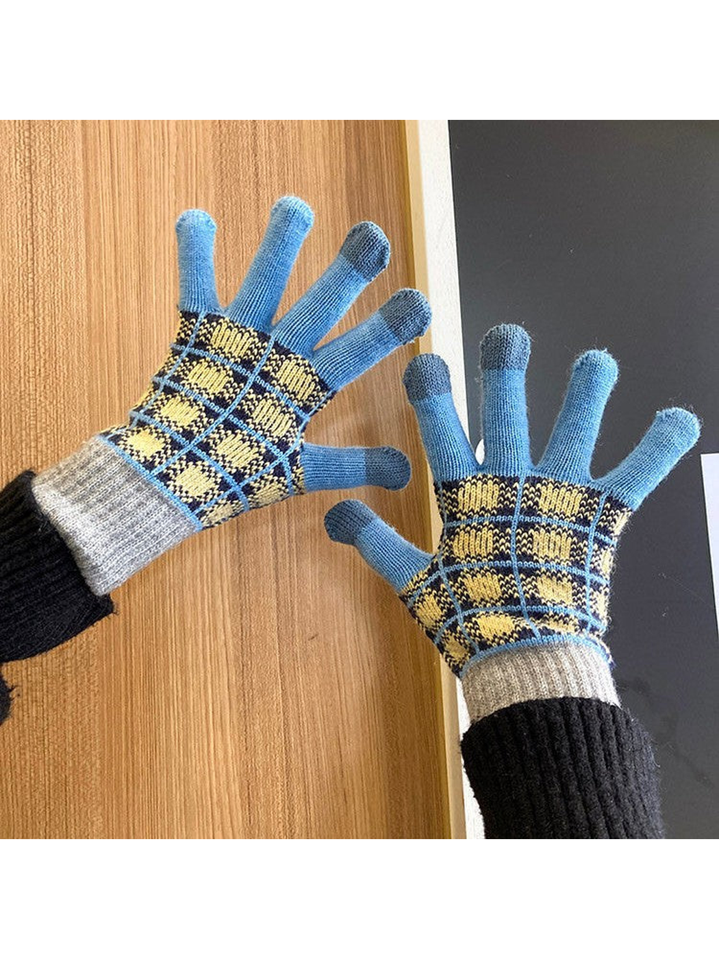 Blue and gray checked gloves worn with palms facing forward