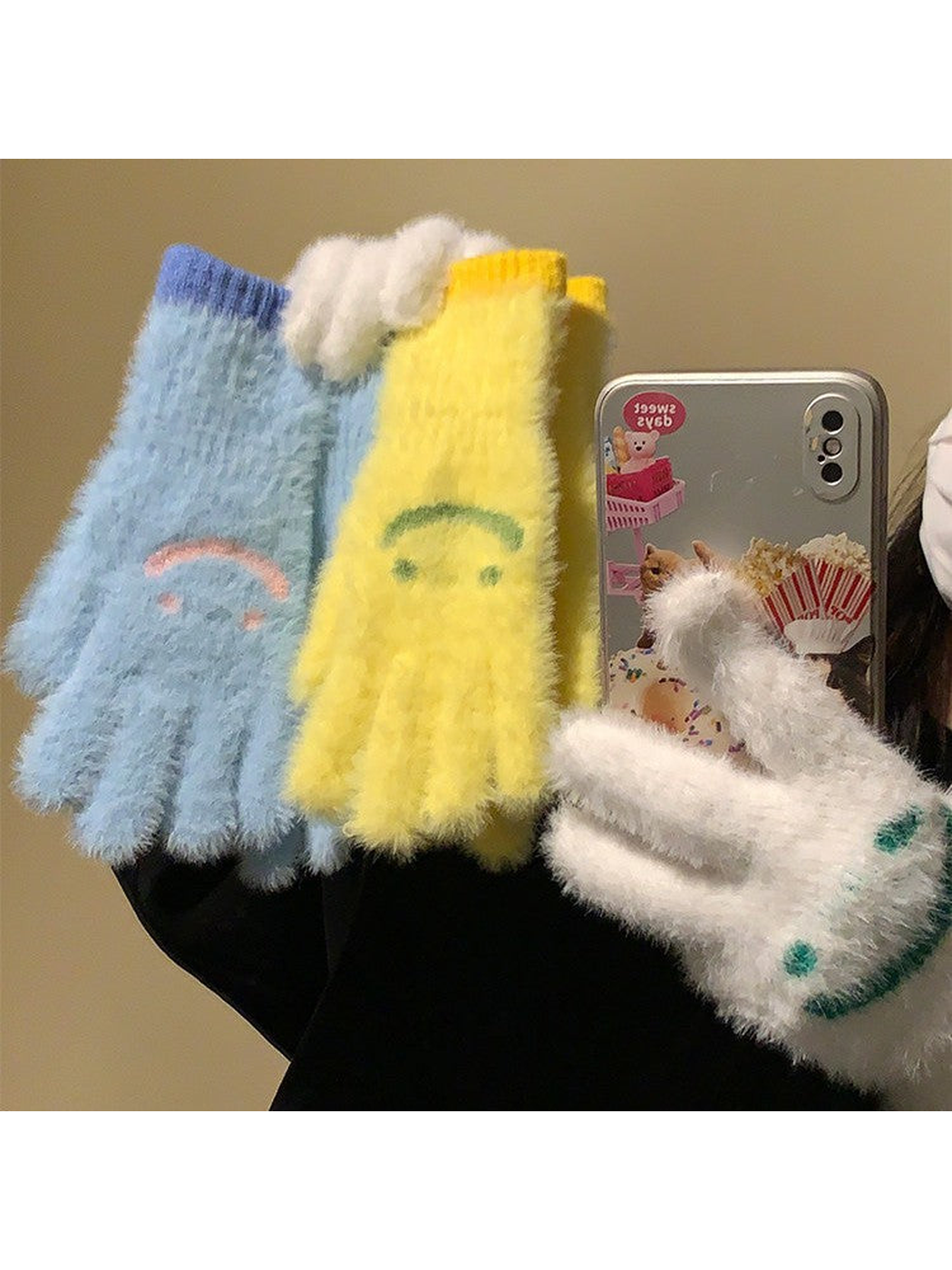 Blue, yellow and white fuzzy smiley-face gloves held together