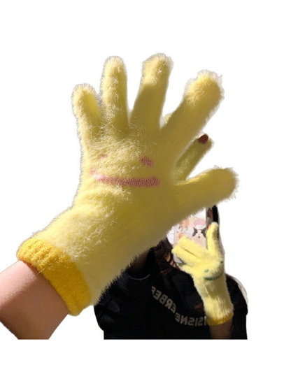 Close view of a yellow fuzzy smiley-face glove and fingertip detail