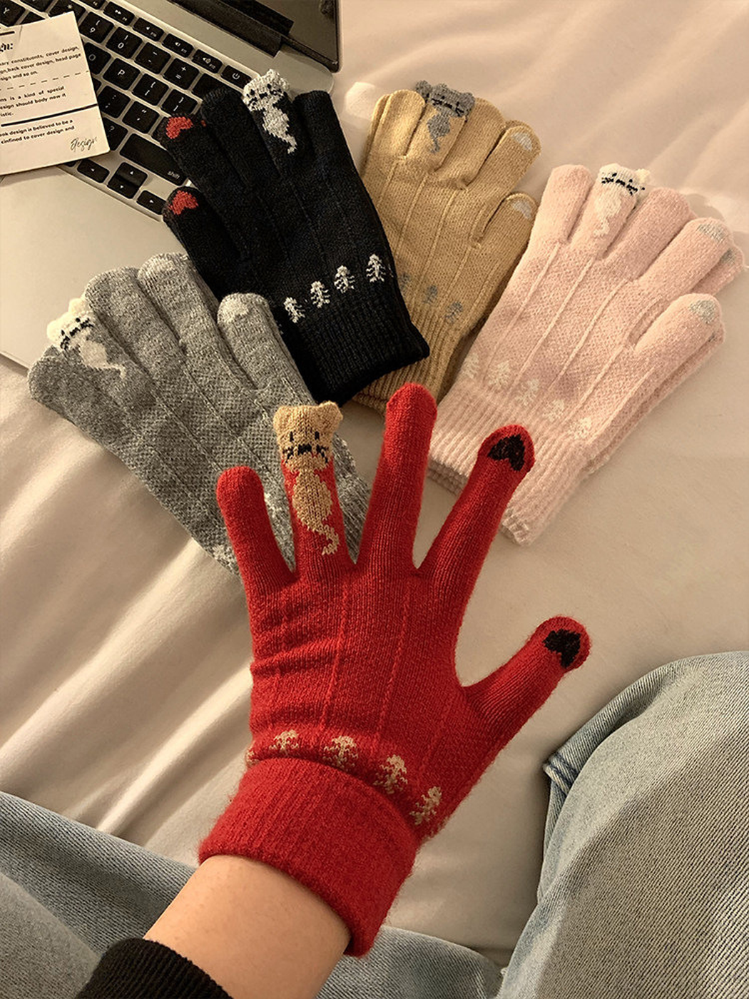 Black, gray, beige, light pink and red cat motif gloves displayed together