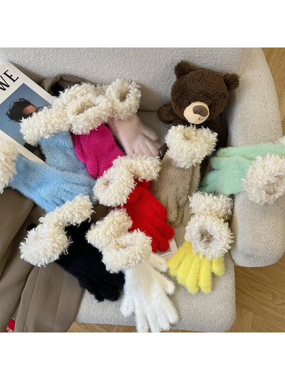 Multiple fuzzy glove colors with curly white cuffs arranged on a chair