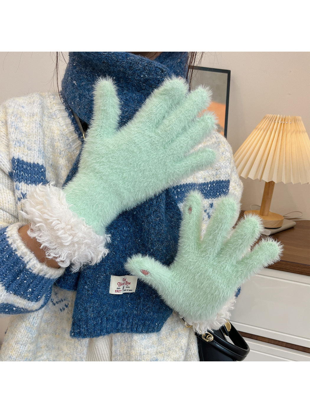 Mint fuzzy gloves with curly white cuffs worn with a blue scarf