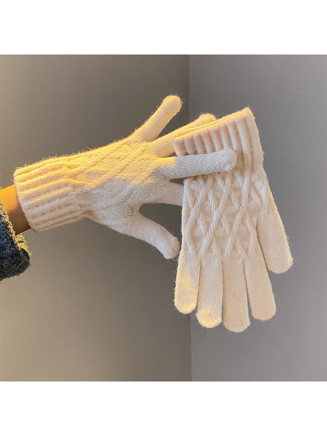Beige cable-knit gloves with ribbed cuffs, worn and held view