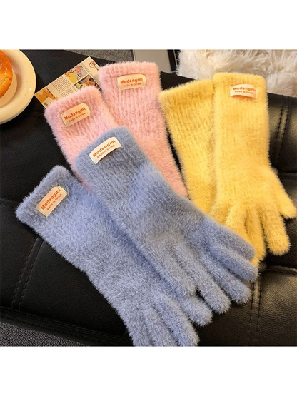 Light blue, pink and yellow fuzzy gloves displayed together